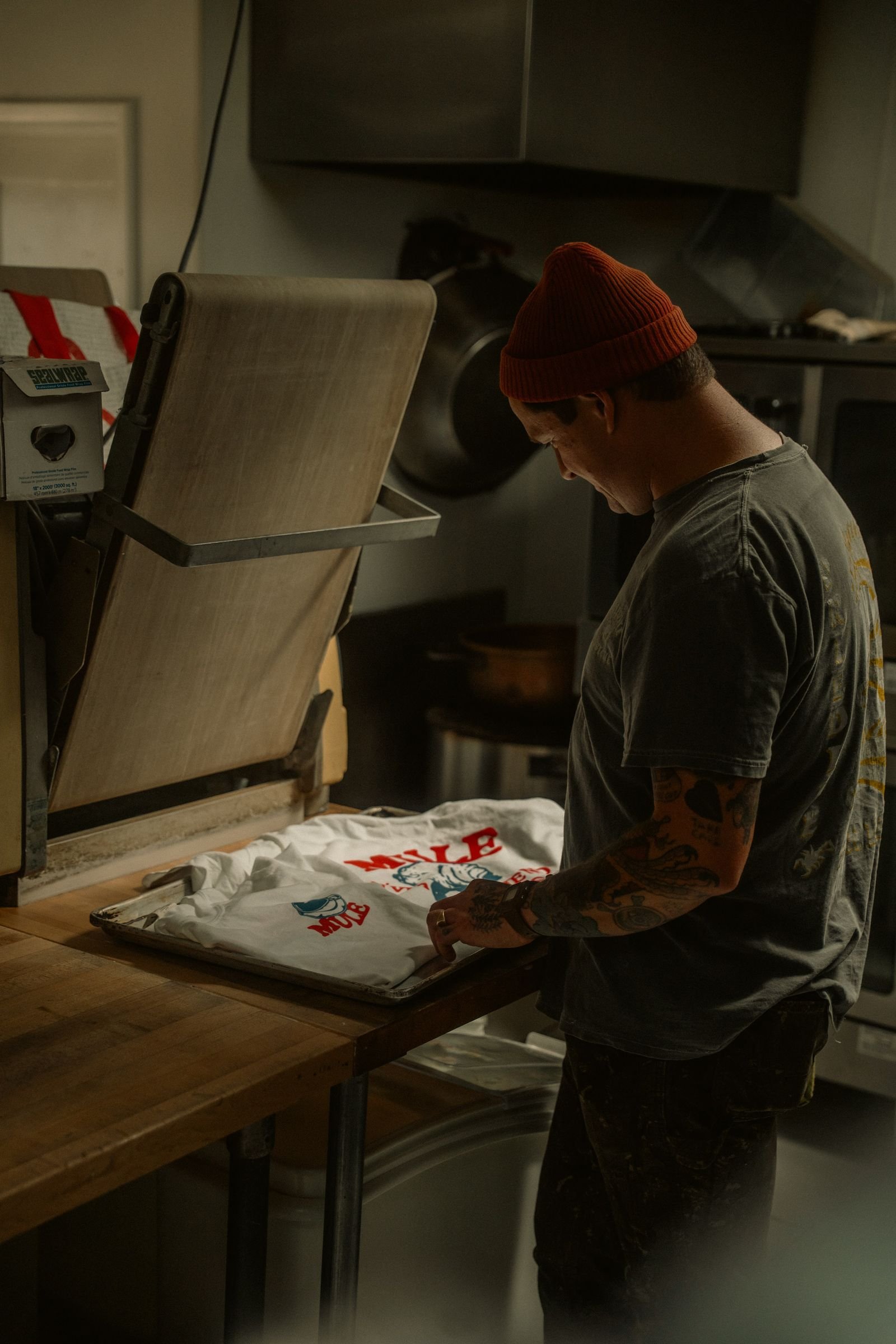 Artisan preparing a printed shirt at a heat press